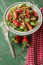 Salad with strawberries served in a plate