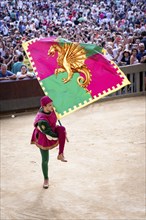 Man carrying a historical flag during the Corteo Storico parade before the Palio di Siena horse race