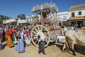 People in traditional clothes and decorated oxcarts