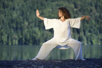 Young woman in white clothes practicing a Tai Chi