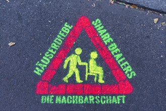 Warning sign against thieves and drugs sprayed with phosphorus paint on street asphalt