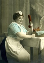 Housekeeper writes a letter with a big sausage in her hand
