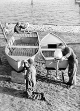 Three men repairing a boat