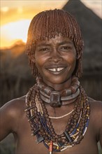 Married woman of the Hamer tribe with necklace at sunset