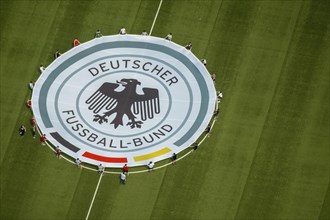 Young football players with rolled out banner with emblem German Football Association