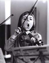Child plays violin and sings