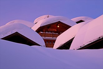Chalets with deep snow in the village at dusk