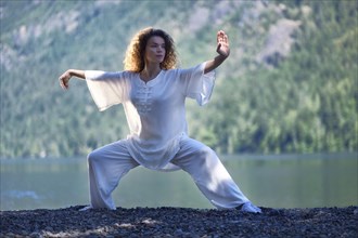 Young woman in white outfit practicing a Tai Chi