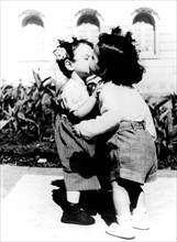 Two children kiss each other