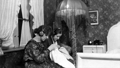 Two women listening to radio with headphones