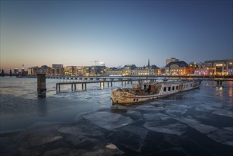 Ice floes in the river Spree between Elsenbrucke and Oberbaum Bridge during blue hour