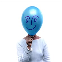 Woman with a blue balloon in front of her face