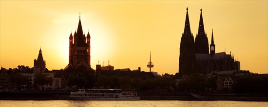 Silhouette of Gross Sankt Martin church with Cologne Cathedral and Rhine at sunset