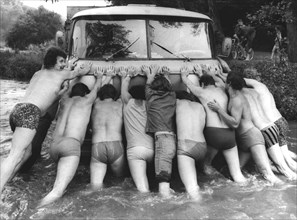 Men push car in water ca. 1970's
