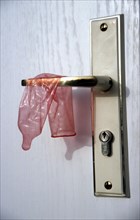 Condom hangs over door handle