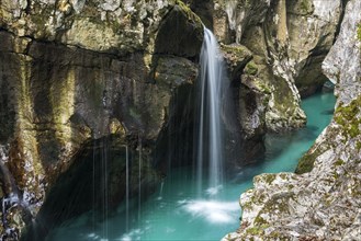 Emerald green wild river Soca flows through rocky gorge