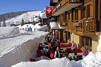 Restaurant terrace on the Dorfstrasse with snow-covered houses
