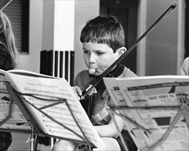 Boy with chewing gum playing the violin