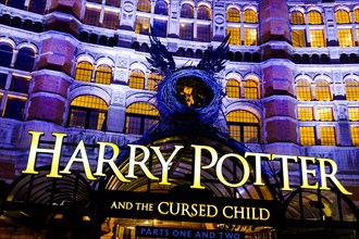 Illuminated facade of the Palace Theatre with advertising for Harry Potter play