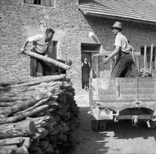 Men load logs onto a wagon