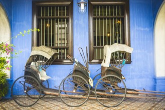 Old rickshaws on the blue wall
