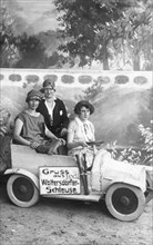 Three women in a small car made of wood