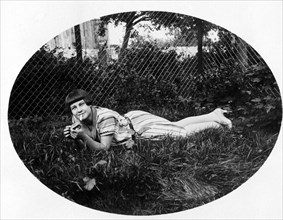 Young woman lying in the grass smoking
