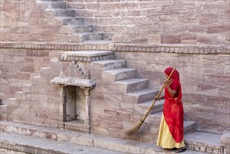 Woman in Sari cleaning the steps at Toorji Ka Jhalara
