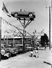 People gazing at car in the air