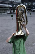 Man with tuba on his head