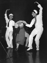 Two sailors dancing with woman in evening gown