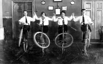 Four acrobats with bicycles