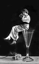 Woman sitting on a champagne glass