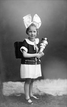 Girl with school bag and big hair bow ca. 1926