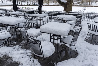 Cafe chairs and tables covered in snow in Central Park in winter