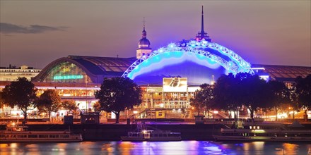 Illuminated Central Station and Musical Dome with Rhine at dusk