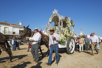 People in traditional clothes and decorated carriage