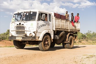 Truck with farm workers on load space