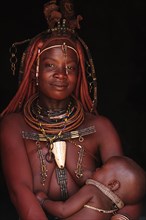 Married Himba woman breastfeeding her baby