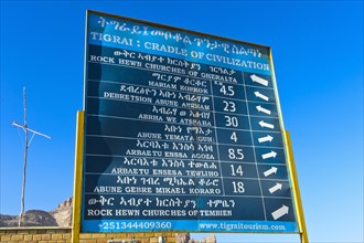 Bilingual signpost in English and Amharic showing rock churches in the Gheralta region