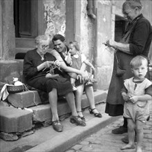 Mother and children shy away from the grandparents while knitting