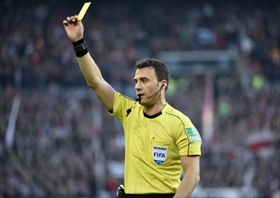 Referee Felix Zwayer gesticulates and shows yellow card as warning