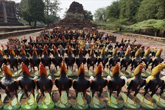 Rooster figures lined up in front of a Buddhist temple