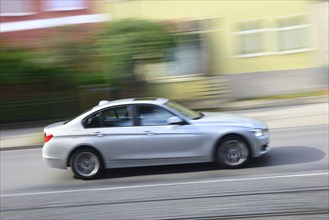 Car 3 Series BMW drives through residential area