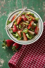 Salad with strawberries served in a plate