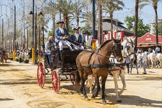 Spaniards in traditional festive dress on horse-drawn carriage