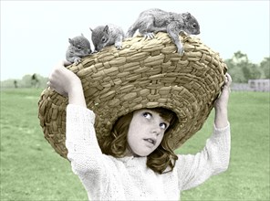 Girl with chipmunks sitting on her straw hat