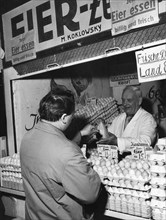Man buys eggs at market stall