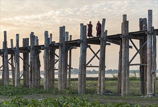 Buddhist monks walking on the U Bein Bridge over Taungthaman Lake