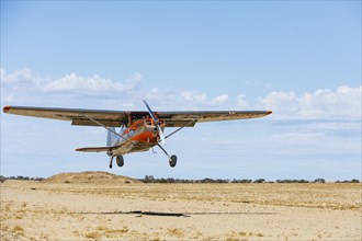 Cessna 170 lands on a sandy runway